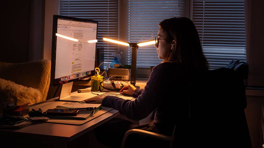 Kateryna Sereda arbejder ved en skærm i lyset fra en skrivebordslampe