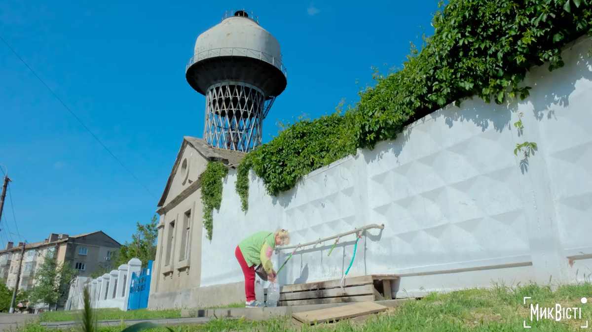 Kvinde henter vand ved et vandtårn i Mykolaiv